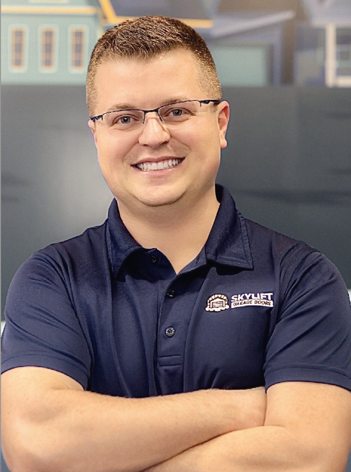 Alex Gaskill in a navy Skylift polo, arms crossed, smiling